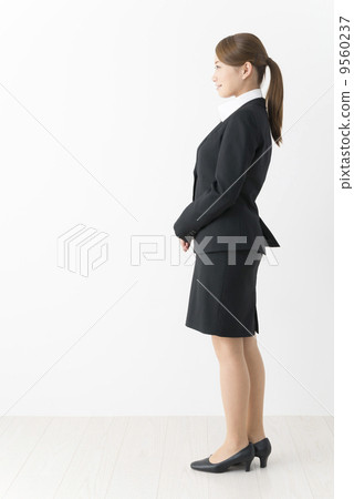A woman in a suits looking sideways (whole body) A woman in a suits looking sideways (whole body) 9560237