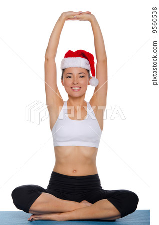 Asian girl doing yoga in a cap of Santa Claus Asian girl doing yoga in a cap of Santa Claus 9560538