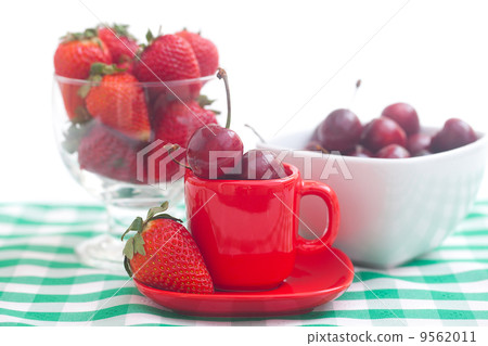 Cherries and strawberry in a ceramic and glass bowl on checkered 9562011