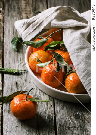 Tangerines with leaves on wooden background Tangerines with leaves on wooden background 9580045