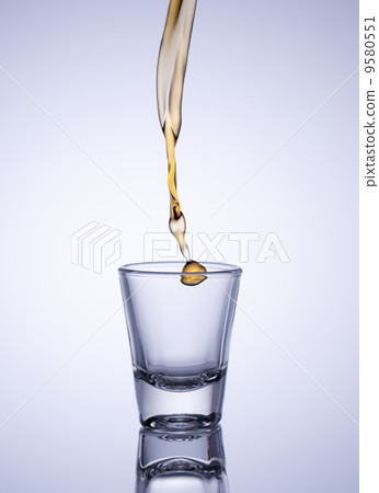 Glass of whiskey with splash 9580551