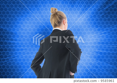 Composite image of businesswoman standing with hands on hips 9585961
