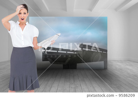 Composite image of shocked classy businesswoman holding newspape 9586209