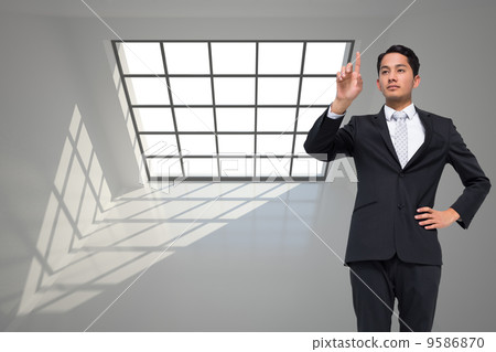 Composite image of unsmiling asian businessman pointing 9586870
