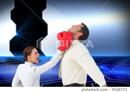 Composite image of businesswoman hitting a businessman with boxi 9588723
