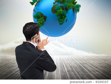 Composite image of thoughtful asian businessman pointing 9589107