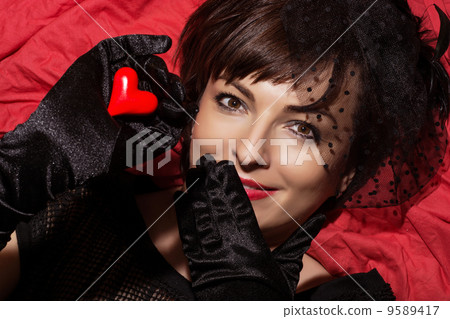Beautiful smiling woman with red heart in hand 9589417