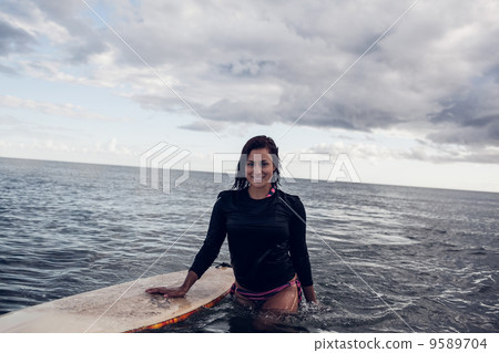 Portrait of a beautiful woman with surfboard in water Portrait of a beautiful woman with surfboard in water 9589704