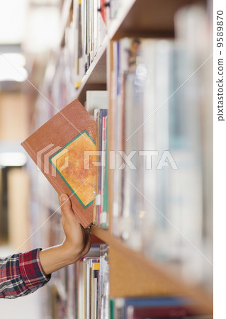 Close up of student taking book out of shelf Close up of student taking book out of shelf 9589870