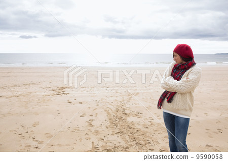 Pretty woman in stylish warm clothing at beach 9590058