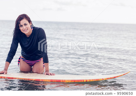 Beautiful young woman with surfboard in water 9590650