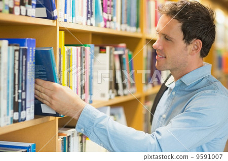 Mature student selecting book from shelf in library Mature student selecting book from shelf in library 9591007