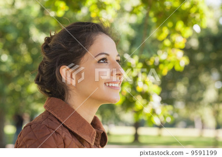 Side view of cute brunette woman wearing a brown coat 9591199