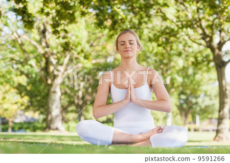 Content peaceful woman meditating sitting on an exercise mat Content peaceful woman meditating sitting on an exercise mat 9591266