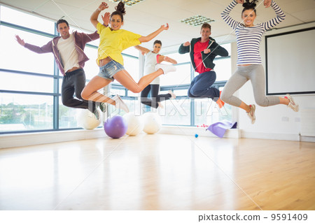 Fit people jumping in exercise room 9591409
