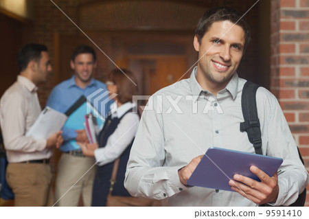 Content male mature student posing in corridor holding his table 9591410