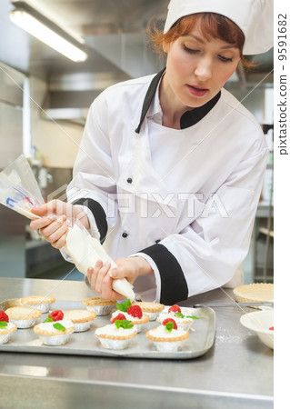 Pretty focused head chef preparing dessert Pretty focused head chef preparing dessert 9591682