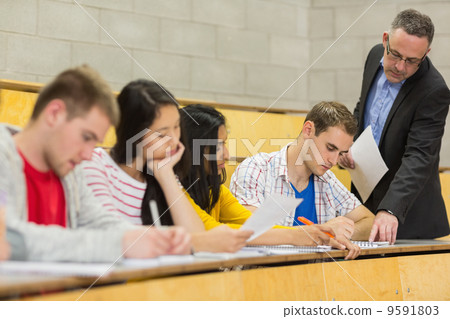 Teacher with students writing notes in lecture hall 9591803