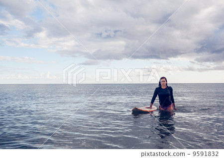 Portrait of a beautiful young woman with surfboard in water 9591832