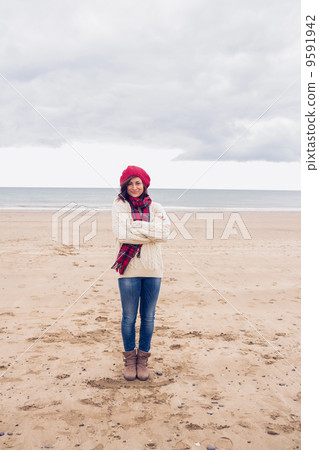 Pretty woman in stylish warm clothing at beach 9591942