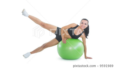 Content active woman doing an exercise on a green fitness ball 9591989