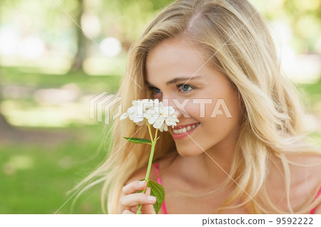Content young woman smelling a white flower Content young woman smelling a white flower 9592222