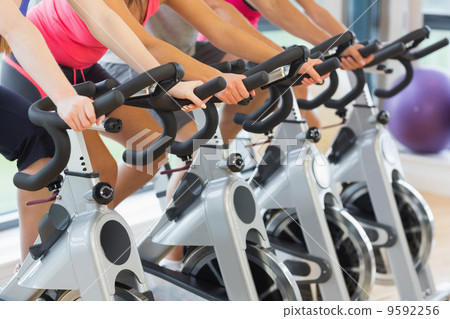 Mid section of people working out at spinning class