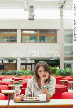 Gloomy student in the cafeteria with food tray Gloomy student in the cafeteria with food tray 9592274