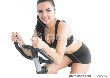 Attractive sporty woman exercising with an exercise bike 9592287