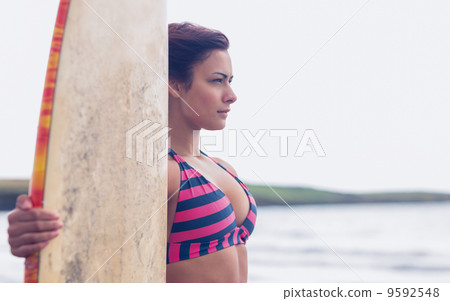 Beautiful woman in bikini with surfboard on beach 9592548