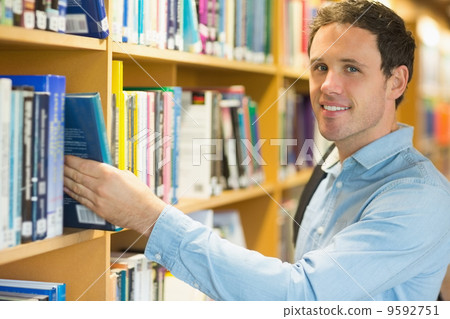 Smiling mature student selecting book from shelf in library Smiling mature student selecting book from shelf in library 9592751