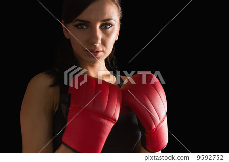 Beautiful sporty woman wearing boxing gloves looking at camera Beautiful sporty woman wearing boxing gloves looking at camera 9592752