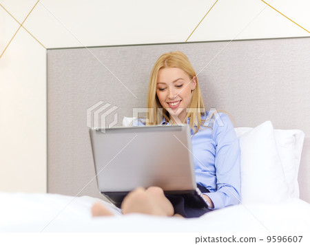 happy businesswoman with laptop in hotel room happy businesswoman with laptop in hotel room 9596607