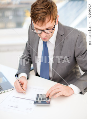 businessman with computer, papers and calculator businessman with computer, papers and calculator 9596992