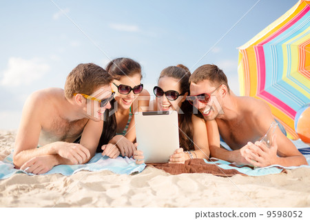 group of smiling people with tablet pc on beach group of smiling people with tablet pc on beach 9598052
