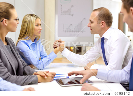 businesswoman and businessman arm wrestling 9598142