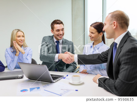 two businessman shaking hands in office 9598635