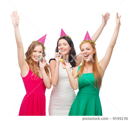 three smiling women in hats blowing favor horns 9599236
