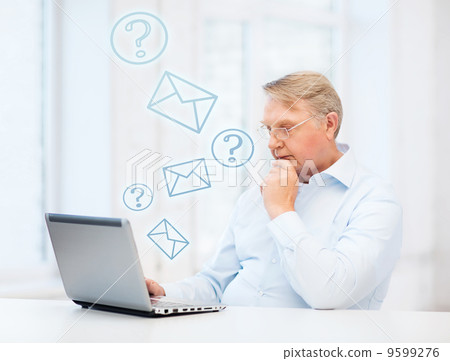 old man in eyeglasses working with laptop at home old man in eyeglasses working with laptop at home 9599276