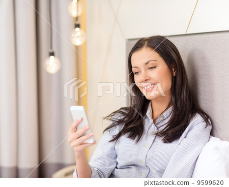 happy businesswoman with smartphone in hotel room 9599620