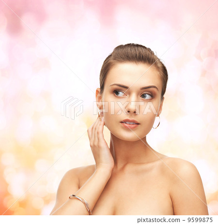 woman wearing gold earrings and bracelet woman wearing gold earrings and bracelet 9599875