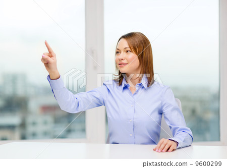 smiling woman pointing to something imaginary 9600299