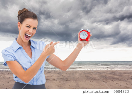 Composite image of businesswoman indicating alarm clock 9604823