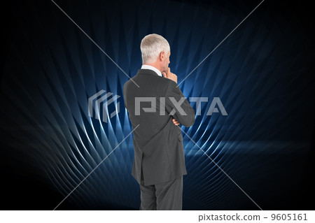 Composite image of thoughtful businessman standing back to camer 9605161
