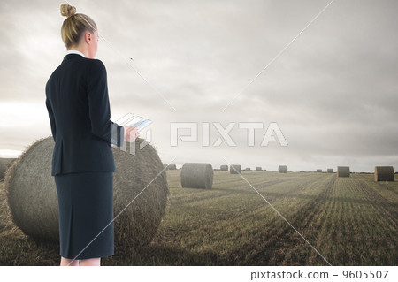 Composite image of businesswoman holding new tablet 9605507