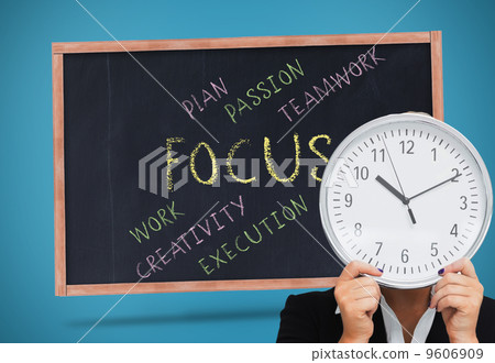 Composite image of businesswoman in suit holding a clock 9606909