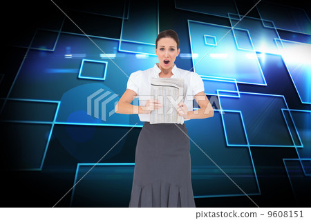 Composite image of shocked stylish businesswoman holding newspap 9608151