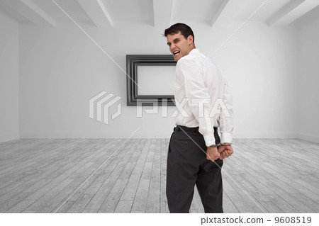 Composite image of rear view of young businessman wearing handcu Composite image of rear view of young businessman wearing handcu 9608519