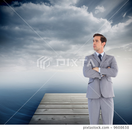 Composite image of serious businessman with arms crossed Composite image of serious businessman with arms crossed 9608638