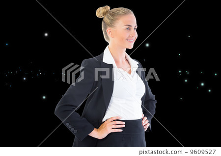 Composite image of businesswoman standing with hands on hips 9609527